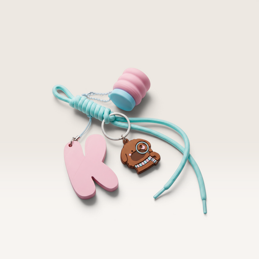 iTsChoCoBu custom keychain bundle featuring a pink initial K, brown dog charm, and pastel mini storage container.