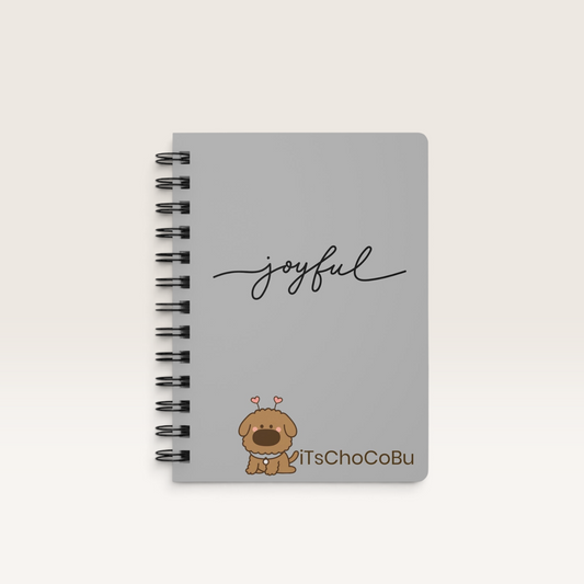 iTsChoCoBu spiral notebook with a gray glossy cover, cute cartoon puppy illustration, and joyful script text.