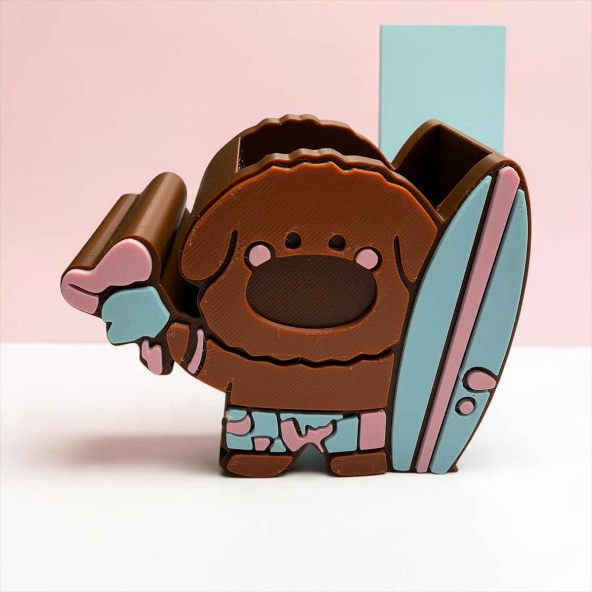 iTsChoCoBu brown puppy desk organizer with a surfboard and ice cream in pink and blue on a pastel background